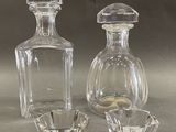 two glass vases and a glass candle holder on a table