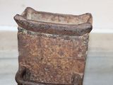 a rusted metal container sitting on the floor