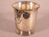 a silver cup with a key in it on a table