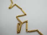 un gros plan sur un collier en or à longue chaîne