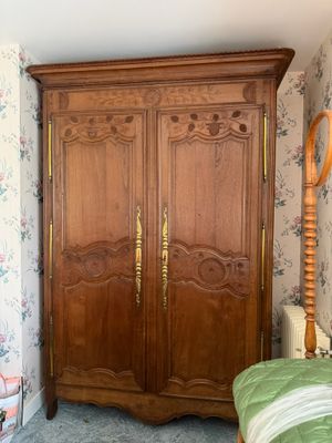 une photo d'une chambre à coucher avec un lit et une armoire en bois