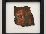 framed photograph of a piece of rusted paper with writing on it