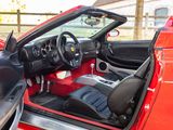 a red sports car with a black leather seat and steering wheel