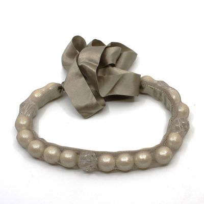 un bracelet orné d'un nœud, posé sur un fond blanc
