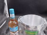 une bouteille d'alcool à côté d'un seau et d'une bouteille de liquide