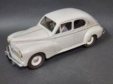 une petite voiture blanche avec un homme au volant
