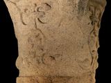 a stone vase with writing on it on a black background