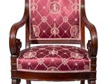 La chaise est en bois et possède une assise rembourrée de couleur rouge.