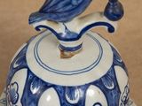 a blue and white bell with a bird on it