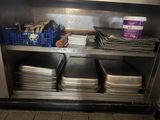 de nombreux plateaux et plats sur l'étagère de la cuisine
