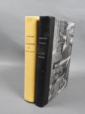 two books sitting on top of each other on a gray surface