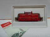 un petit train rouge dans une boîte blanche posée sur une table