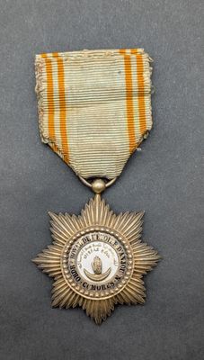 an old medal with a star on it sitting on a table