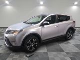 Une Toyota RAV argentée est garée dans une pièce au sol à carreaux.