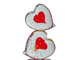 two glass hearts stacked on top of each other on a wooden stand