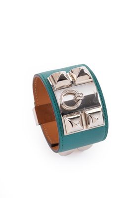 un gros plan sur un bracelet en cuir vert muni d'un fermoir en métal