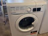 une machine à laver et un sèche-linge blancs posés à même le sol dans une pièce
