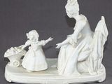 a figurine of a woman and a child sitting on a bench