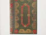 an old book with a green cover and a red border