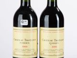 deux bouteilles de vin rouge posées l'une à côté de l'autre sur une surface blanche