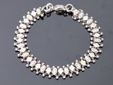 un bracelet en argent orné de pierres blanches sur un fond noir