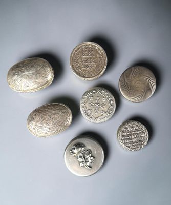 six silver coins are arranged in a circle on a white surface