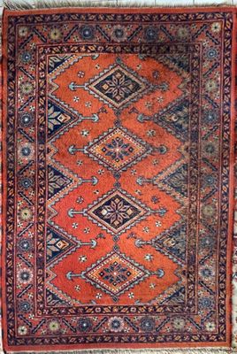 an orange and blue rug with a diamond design on it