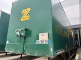 un grand camion vert garé devant un immeuble