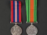 two medals with ribbons and a medal on a black background