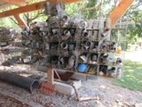 une pile de casseroles et de poêles posée sur un support dans une cour