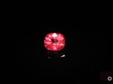 a close up of a red diamond in the dark