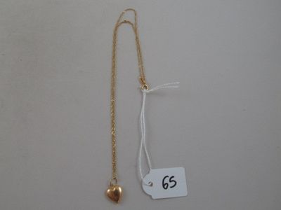 a close up of a necklace with a gold heart on it