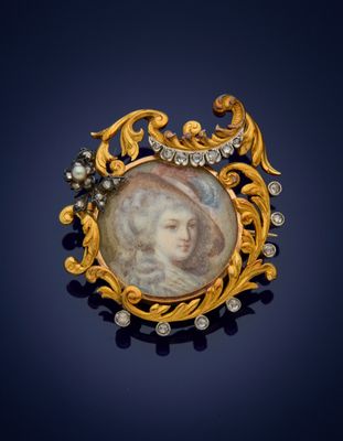 a close up of a gold broochle with a picture of a woman