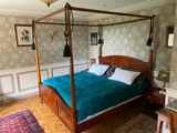 un lit à baldaquin dans une chambre avec du parquet