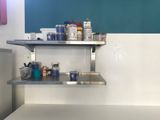 a metal shelf that has some paint and other items on it