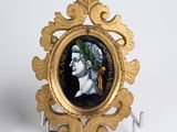 an image of a gold frame with a picture of a man wearing a crown