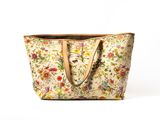 the large floral tote bag is made of canvas and has a leather handle