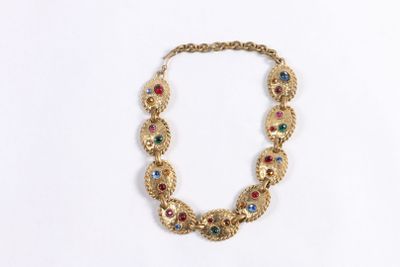 un gros plan sur un collier en or orné de pierres multicolores