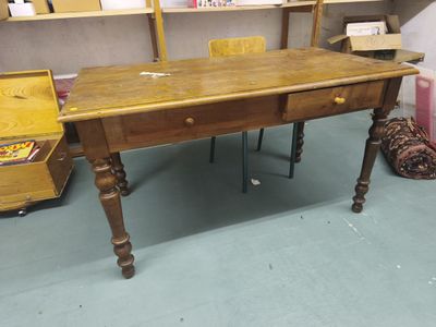 Un bureau plat en bois naturel ouvrant par deux tiroirs en c…