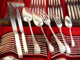beaucoup de cuillères et de fourchettes en argent dans un coffret rouge
