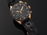 a close up of a watch on a black surface