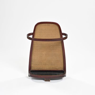 le dossier d'une chaise dont l'assise et les accoudoirs sont marron