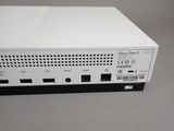 a close up of a white xbox one s console sitting on a table