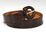 un gros plan sur une ceinture marron avec une boucle dorée