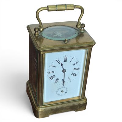 a small brass clock with a blue face on a white background