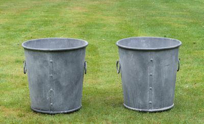 deux poubelles en métal posées sur l'herbe dans le jardin