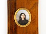portrait d'une femme en robe noire dans un cadre en bois