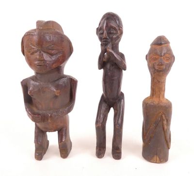 trois figurines en bois représentant un homme et une femme debout l'un à côté de l'autre