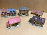 Plusieurs maisons miniatures sont posées sur une table avec un fond marron.