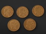 four gold sovereigns, one of which has a crown on it